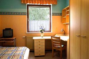 Un dormitorio con escritorio y un jarrón de flores. en Apartment Wurth, en Groß-Siegharts