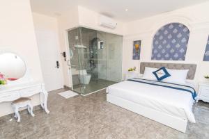 a bedroom with a white bed and a glass shower at Sun Beach Hotel in Vung Tau