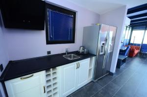 eine Küche mit einer Spüle und einem Kühlschrank in der Unterkunft Batumi Palm Hotel in Batumi