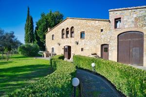 a large stone building with a large garage at Hotel Mas Rabiol -Costa Brava-Emporda-Only Adults in Peratallada