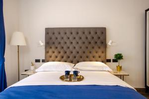 - un lit avec 2 verres sur un plateau dans l'établissement Villa Brandestini, à Pula