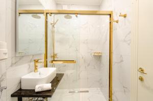 La salle de bains est pourvue d'un lavabo et d'une douche. dans l'établissement Villa Brandestini, à Pula