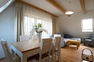 Prestige Apartamenty Smrekowa في زاكوباني: طاولة غرفة الطعام مع إناء من الزهور عليها