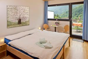 a bedroom with a bed and a large window at Eco-Hotel Cristallina in Coglio