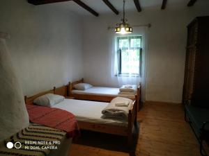 a room with three beds and a window at Darutollas Vendégház in Ópusztaszer