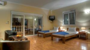 a bedroom with a bed and a couch and a chair at Castellamare Residence in Petrovac na Moru