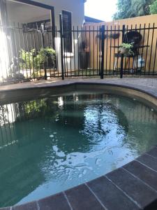 uma piscina de água em frente a uma cerca em The Tropical Sanctuary em Darwin