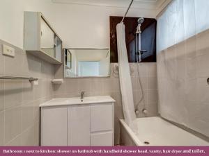 a bathroom with a sink and a shower and a tub at Wollongong station holiday house with Wi-Fi,75 Inch TV, Netflix,Parking,Beach in Wollongong +43 photos