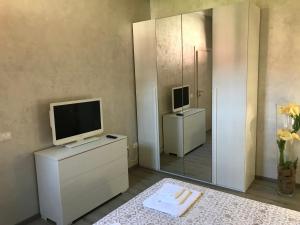 een woonkamer met een televisie en een spiegel bij Vea Apartment in Padenghe sul Garda