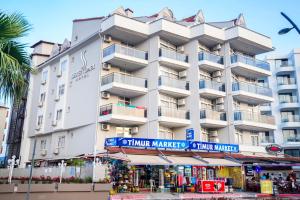 un gran edificio blanco con un mercado frente a él en Seren Sari Hotel, en Marmaris