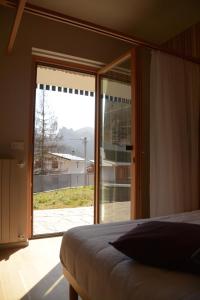 une chambre avec un lit et une grande fenêtre en verre dans l'établissement RELEVEN GUEST HOUSE, à Vernante