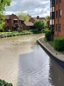 einen Fluss in einer Stadt mit Häusern und Gebäuden in der Unterkunft AB - Top floor 2 bed modern town centre apartment with parking for one vehicle in Stratford-upon-Avon