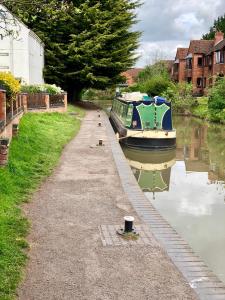 a boat is docked on a canal next to a house at AB - Top floor 2 bed modern town centre apartment with parking for one vehicle in Stratford-upon-Avon