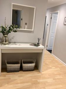 a bathroom with a sink and a mirror at AB - Top floor 2 bed modern town centre apartment with parking for one vehicle in Stratford-upon-Avon