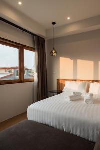 um quarto com uma grande cama branca e uma janela em U Chiangkhan em Chiang Khan