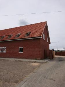 een rood bakstenen gebouw met een rood dak bij Wood Yard Cottages in Long Sutton
