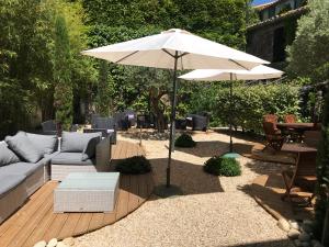 a patio with a couch and an umbrella at Hotel Du Pont Vieux in Carcassonne