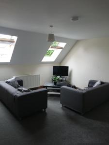 a living room with two couches and a tv at 2 Wood Yard Cottages, Red Mayes Farm in Spalding