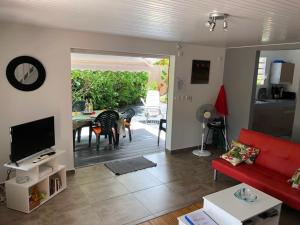 a living room with a red couch and a table at Cap Colibri in Petit-Bourg