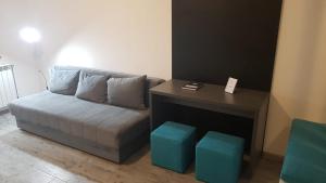 un divano in una stanza con un tavolo e due sgabelli blu di Apartments REST - Centar a Novi Sad