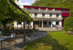 un bâtiment avec une table et des chaises devant lui dans l'établissement Eco-Hotel Cristallina, à Coglio