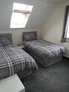 a bedroom with two beds and a skylight at 2 Wood Yard Cottages, Red Mayes Farm in Spalding