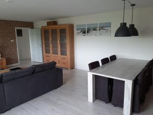 sala de estar con mesa y sofá en Iefjeshoeve, en Petten