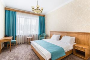 Pokój hotelowy z łóżkiem i biurkiem w obiekcie Zolotaya 7 Hotel Domodedovo w mieście Domodiedowo