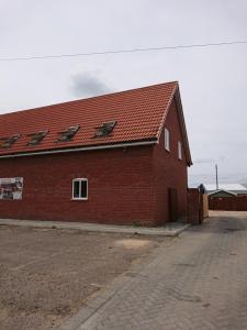 un edificio de ladrillo rojo con techo rojo en 2 Wood Yard Cottages, Red Mayes Farm, en Spalding