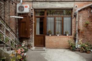 a brick building with a door with potted plants at Tbilisi Apartment in Tbilisi City