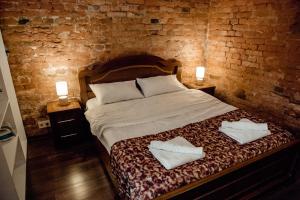 شقة تبليسي في تبليسي: غرفة نوم عليها سرير وفوط