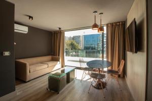 sala de estar con mesa, sillas y sofá en One Nk Apartments, en Santiago