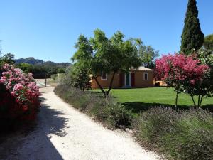 un camino de tierra que conduce a una casa con árboles y flores en Mas'Xime en Saint-Rémy-de-Provence