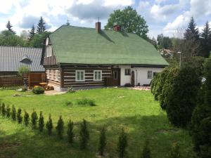 ein kleines Holzhaus mit grünem Dach in der Unterkunft Rodinná chalupa jen pro sebe in Harrachov