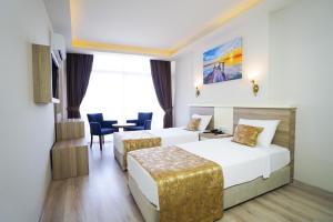 una habitación de hotel con dos camas y una mesa en Seren Sari Hotel, en Marmaris 21 fotos más