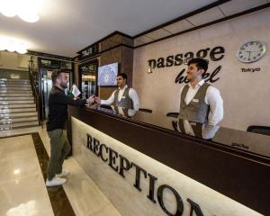 a man standing at a bar talking to two men at Passage Boutique Hotel in Baku