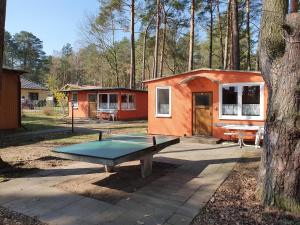 una mesa de ping pong frente a una casa pequeña en Ferienanlage "Am Sidowsee", en Himmelpfort