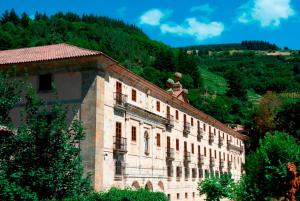 ein Steingebäude mit einer Statue darüber in der Unterkunft Parador de Corias in Cangas del Narcea