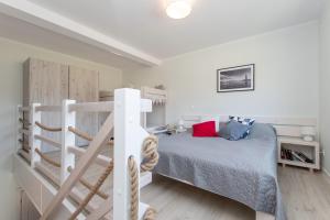 une chambre avec un lit superposé et une échelle dans l'établissement Apartamenty Bieg, à Ustka