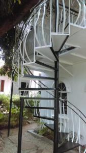 a spiral staircase in front of a white house at The Quiet Escape Loft in Kingston