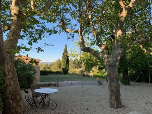 a table and a swing hanging from a tree at le Mas des Pignes -adults only in Aix-en-Provence