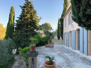a driveway leading to a building with trees and plants at le Mas des Pignes -adults only in Aix-en-Provence