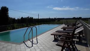 eine Reihe von Stühlen neben einem Pool in der Unterkunft Le Bozze "Il Leccino" con piscina, WI-FI, posto auto in Castagneto Carducci
