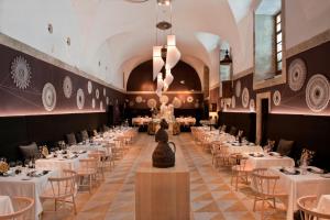 a dining room with white tables and chairs at Parador de Corias in Cangas del Narcea