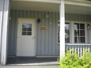 a house with a white door and a sign on it at Aslak Apartment in Saariselka