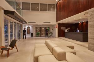 a lobby of a building with a couch and chairs at Flix Hotel in Maceió +43 photos