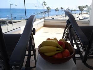 uma taça de fruta numa mesa com vista para o oceano em Lighthouse by the Sea Lovely 2Bdr Apartment em Pafos