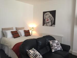 a bedroom with a bed and a black leather chair at Old Picture House in Seaton