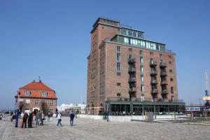 a tall brick building with people walking in front of it at Appartement Altstadtblick im Ohlerich-Speicher in Wismar