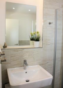 a bathroom with a sink and a mirror at Appartement Altstadtblick im Ohlerich-Speicher in Wismar +16 photos